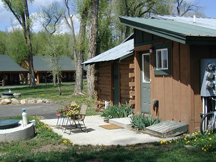 Home page, View of rustic cabin in summer time with lush veggitation and scenary 